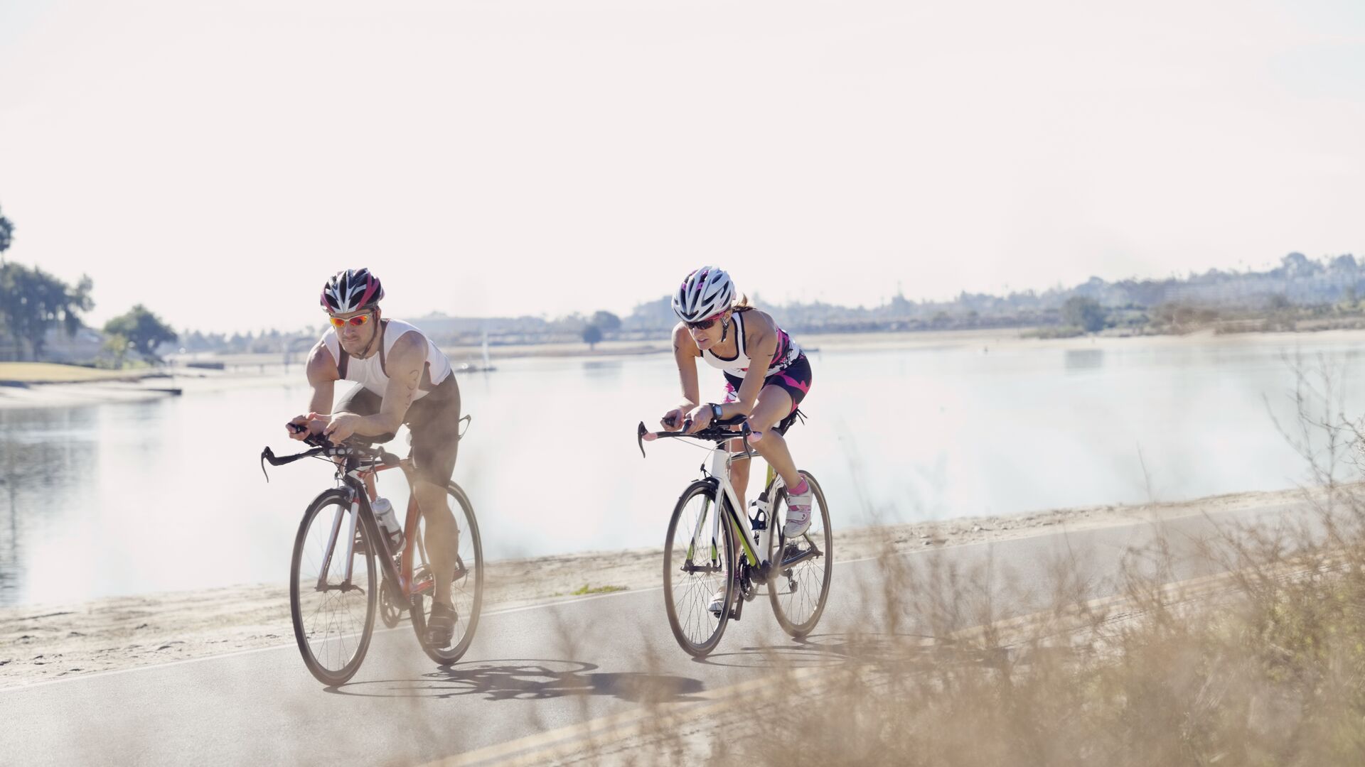 Triathletes riding bicycles on street