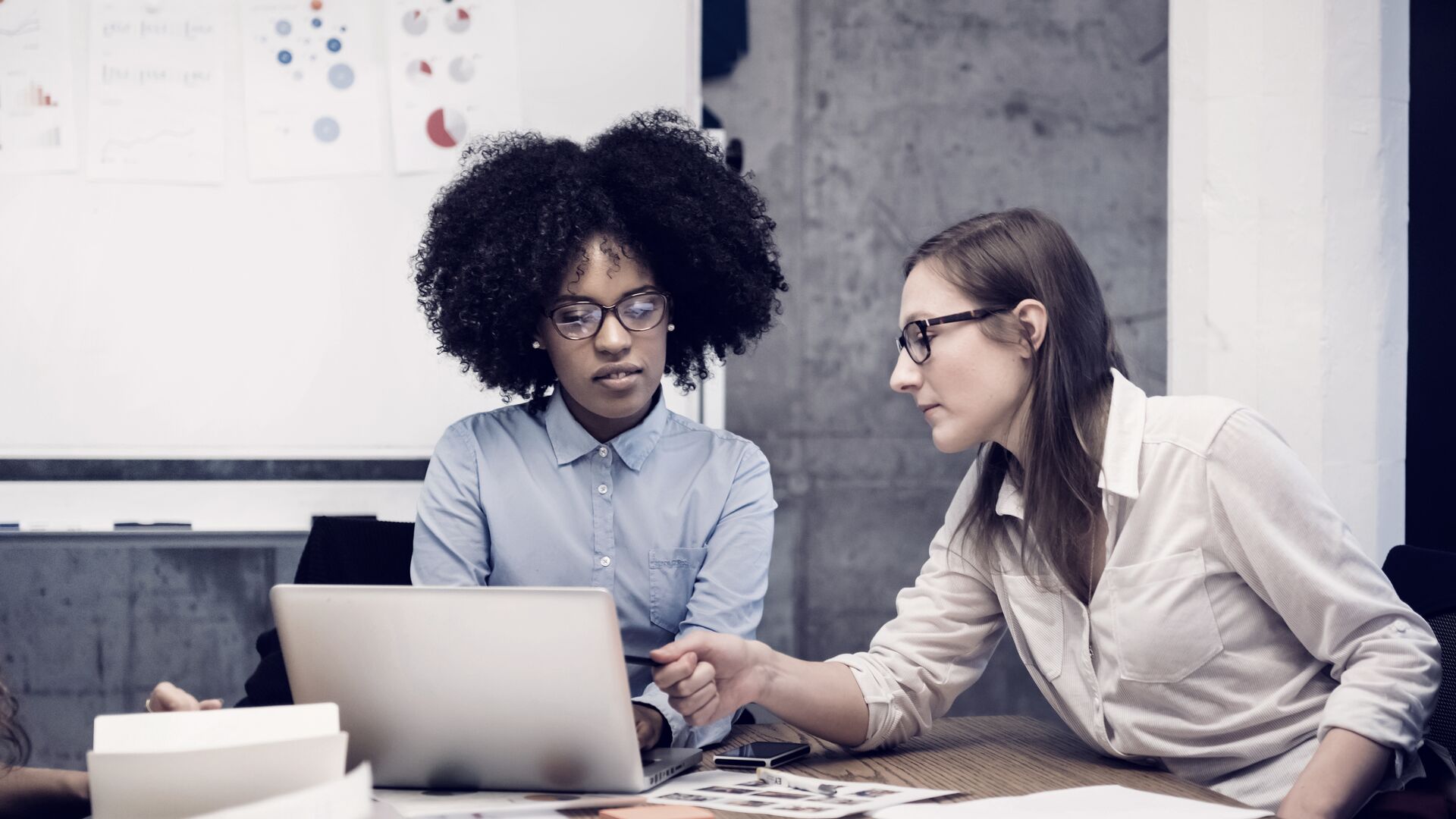 Two young women having a discussion in an office