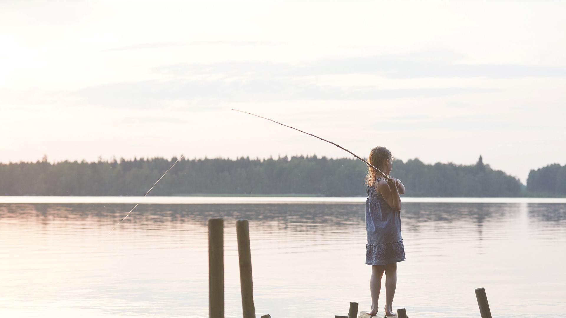 girl fishing by a lake