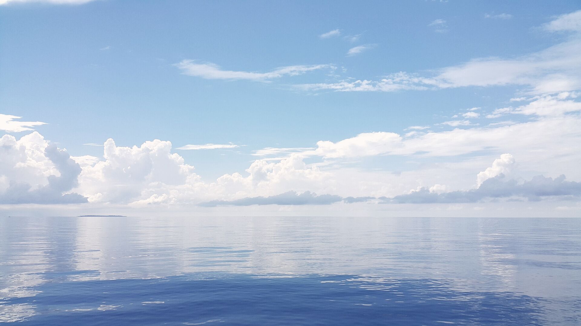 Idyllic view of seascape against cloudy sky