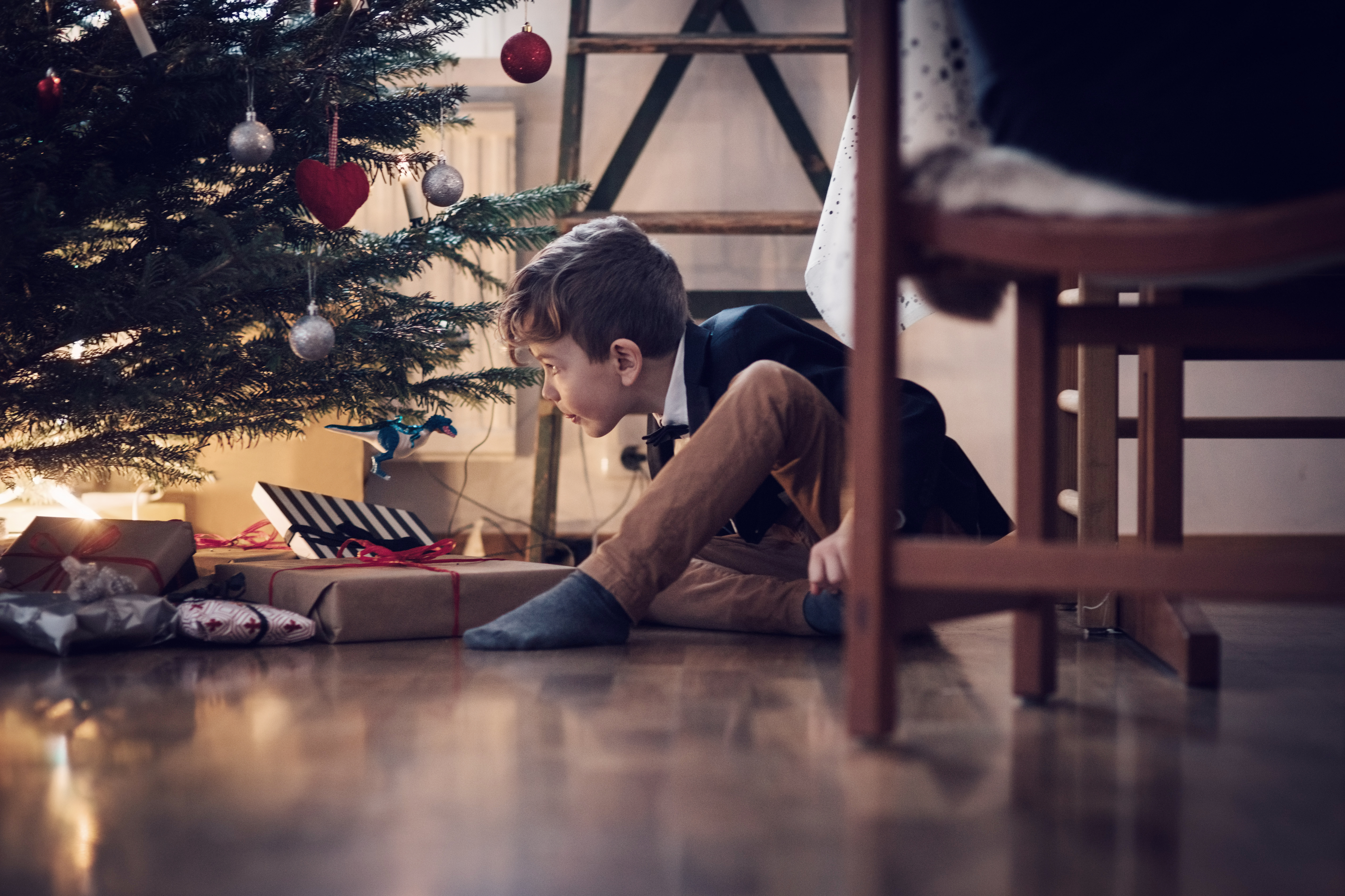 Boy looking at Christmas tree and presents