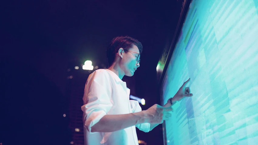 Asian man touching large digital screen