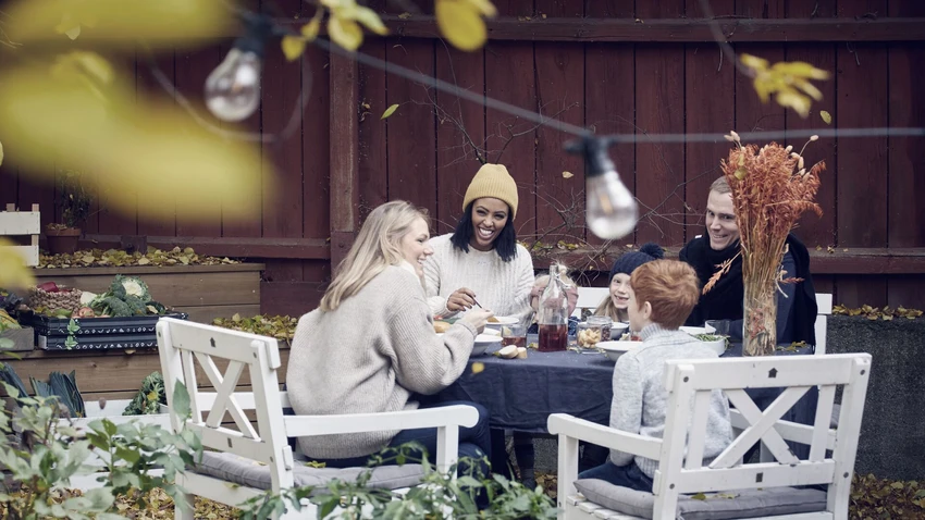 smiling-family-and-friends-sitting-at-table-for-social-gathering