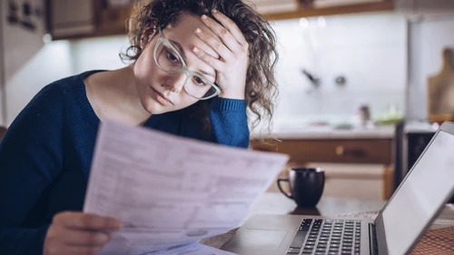Woman going through bills, looking worried