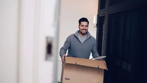 Young man carrying moving box