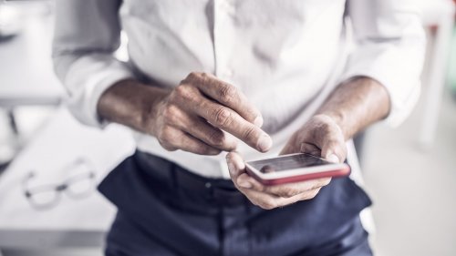 Close-up of businessman using cell phone in office