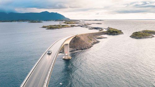 Car driving across the atlantic road in Norway at sunset
