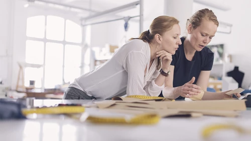 two women discussing business at factory