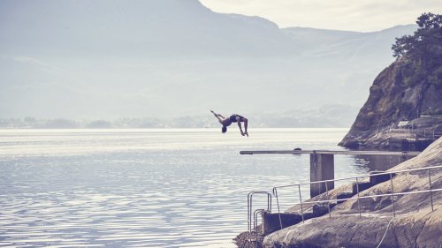 man jumping from bridge in a fjord