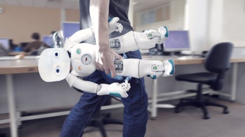 man carrying robot in office