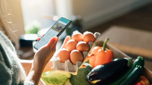 young-woman-ordering-groceries-online-with-smartphone
