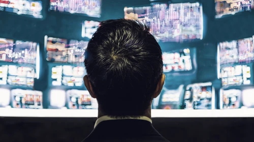 businessman-trader-looking-at-monitor-with-stock-exchange-graph