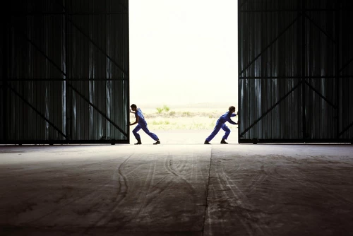 Two farmers opening barndoors