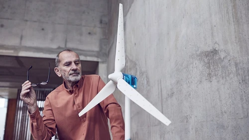 Senior man looking at prototype of wind turbine 