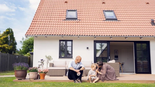 Parents and child in front of house