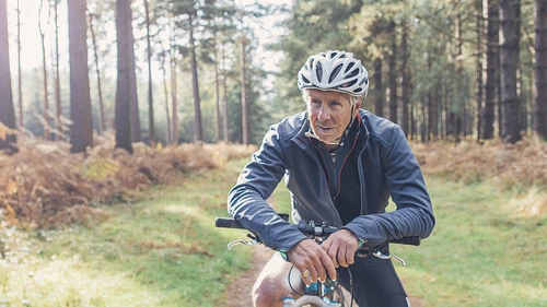Elderly man on bicycle in the woods