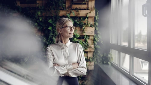 Businesswoman in green office looking out of window