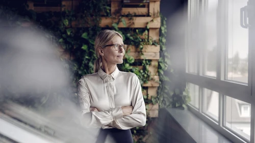 Businesswoman in green office looking out of window1920x1080.jpg