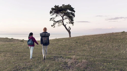 Mother and daughter hiking on field