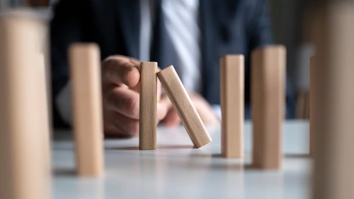 man stopping domino effect