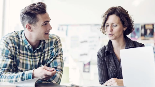 Employees talking at laptop