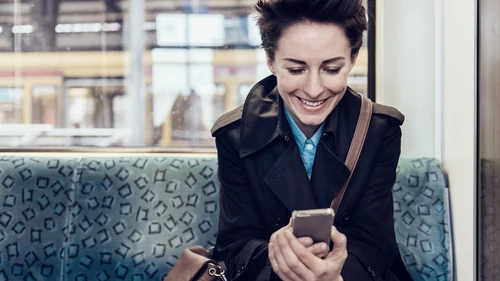 Businesswoman with smart phone in commuter train