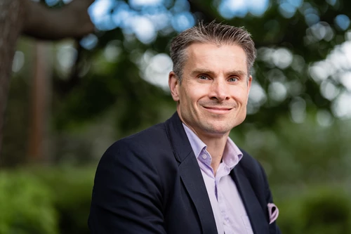 Nordean pääanalyytikko Jan von Gerich on pukeutunut vaaleaan kauluspaitaan ja siniseen pikkutakkiin ja katsoon kameraan taustallaan metsäinen puistomaisema.