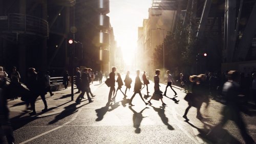 Business people walking through a city at dawn
