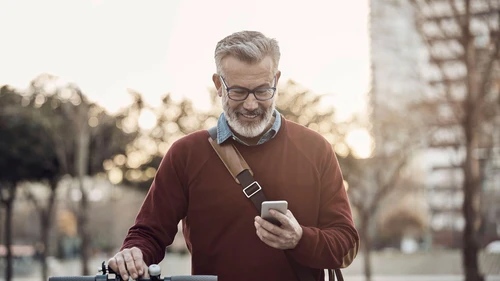 Happy man with mobile phone and bicycle