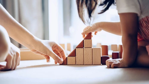 Mother and daughter playing with wooden blocks