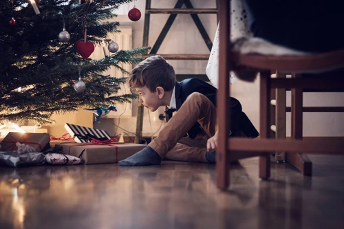 Boy looking at Christmas tree and presents