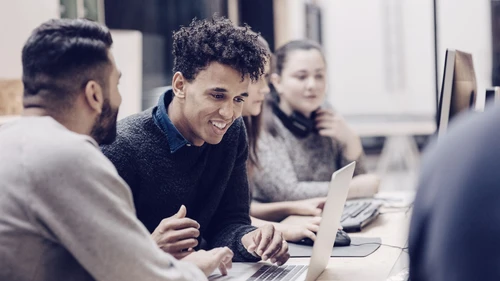 Entrepreneurs discussing over computers on desk in office