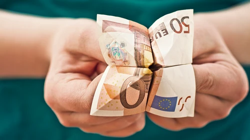 Hands holding a folded euro note