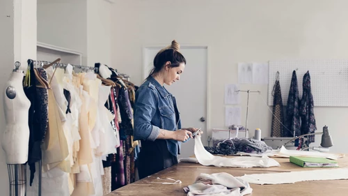 Female seamstress cutting pattern
