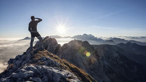 Climber standing on a mountain peak