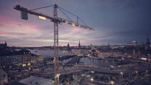 Aerial-view-of-illuminated-city-against-sky-during-sunset