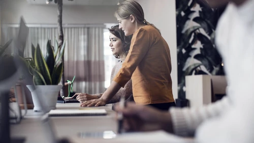 Female business people working at table in office
