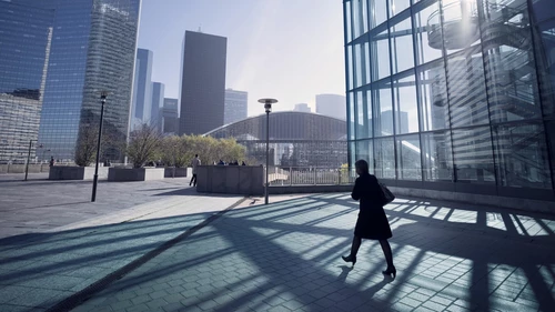 Silhouette of businesswoman walking towards center of business district in Paris, France.
