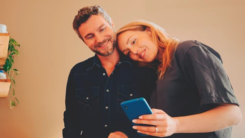 A man and a woman looking at a mobile phone