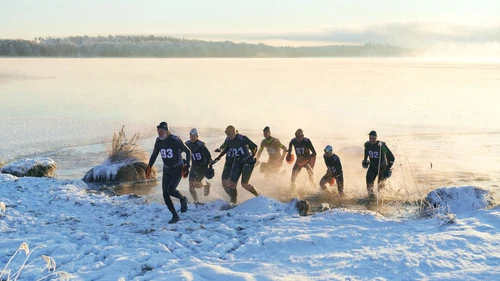 Group of swim runners running up from the lake in winter