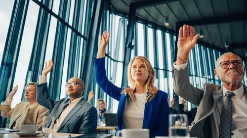 Professionals raising hands to share corporate insights