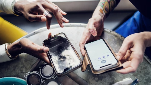 Friends sending money to each other using smart phones