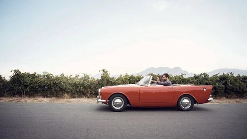 Couple driving in an old convertible car
