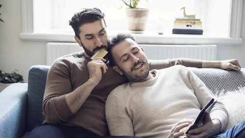 Two people online shopping in a living room