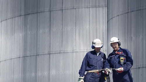 engineers-by-oil-storage-tower