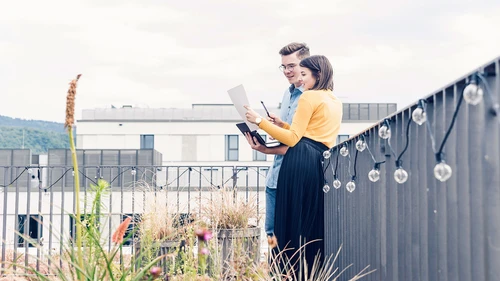 Casual businessman and woman with laptop and documents