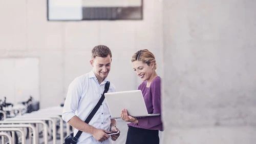 Business Couple Discussing and Using Portable Devices