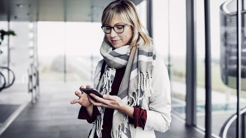 Businesswoman with smart phone standing at the airport