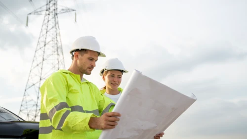 High voltage engineers working on the field, checking compare blueprint and condition of the Electrical Power Pole components