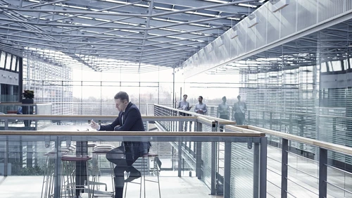 Businessman doing paperwork sitting at office balcony table